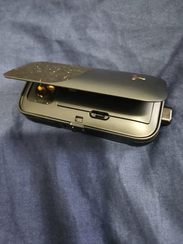 A customer shows their black Legacy PRO 2 vaporizer with the top cover open.