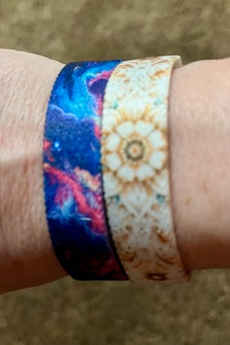 Close-up of a reviewer wearing two Not Today, Anxiety Bracelets, showing the colorful galaxy and mandala outer patterns.
