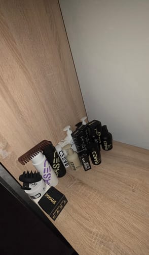 Customer's collection of hair care products, including the Beachy Flow Duo, arranged on a wooden shelf.