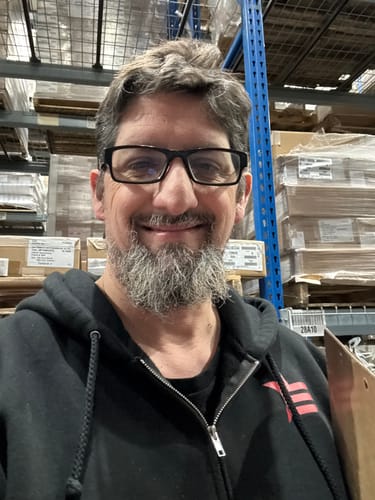 Customer wearing the black Rogue Zip Hoodie with the red star logo on the chest in a warehouse.