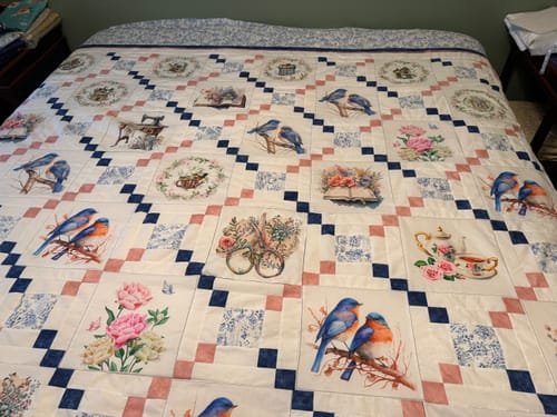 Reviewer's stunning memory quilt made with Floral Bible Fabric Panels laid flat on a bed, showing the detailed grid pattern.