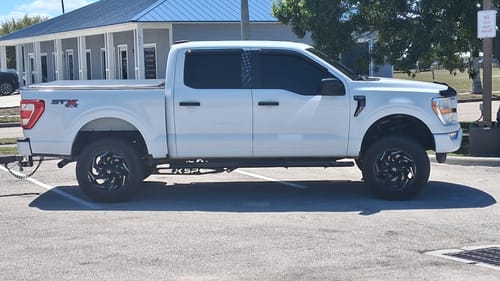 Customer's lifted white Ford F150 with the black Traction Bar Kit installed underneath.