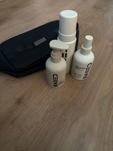 Reviewer's Hydration & Refresh Duo products in their matching white bottles, displayed on a wooden surface with a black pouch.