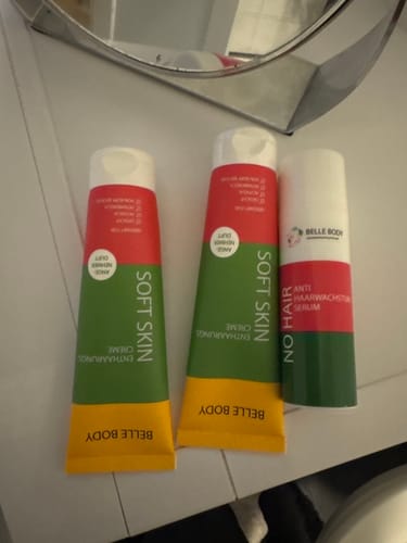 Ein Kunde zeigt die zwei Enthaarungscremes und das Serum des Haarfrei Gesichts Duos auf einer Ablage.