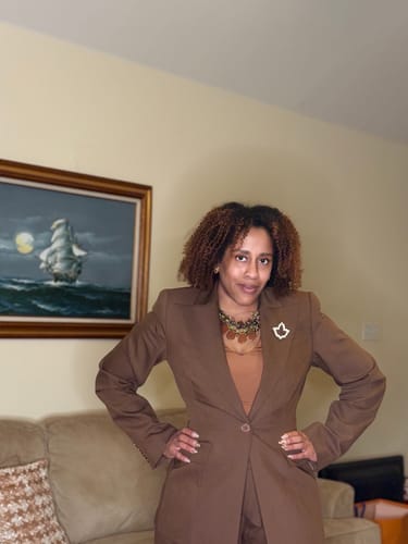 Close-up of the reviewer in the brown suiting set, showing the top of the Pleated Wide-Leg Pant.