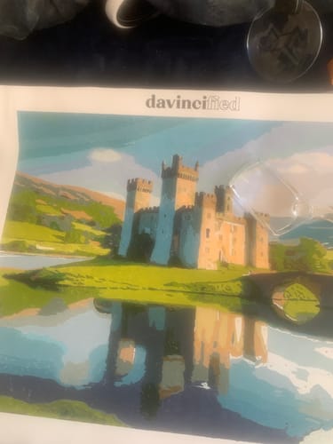 Reviewer's completed painting from the Scottish Castle paint by numbers kit, showing the castle reflected in water.