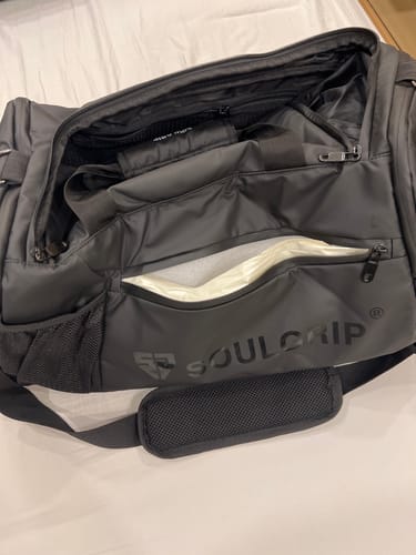 Reviewer's black SoulGrip SoulPack bag showing the torn lining inside the front waterproof pocket.