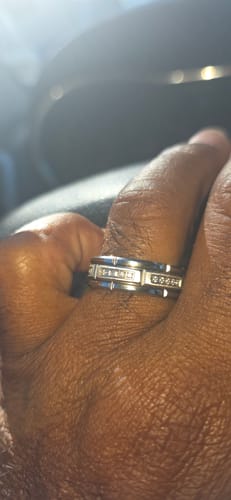 Close-up of a customer's hand wearing the Kaelen ring, showing the polished tungsten band and zircon inlays.