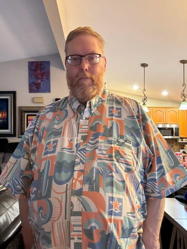 Reviewer wearing the Disney "Mickey's Endless Summer" shirt, showing the fit and colorful pattern.