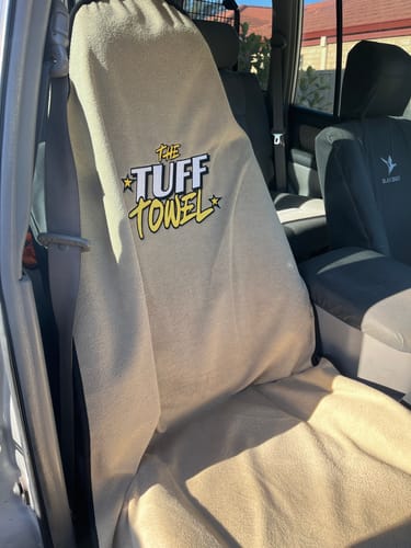 Customer's beige Tuff Towel seat cover shown fitted on the driver's seat of a car.