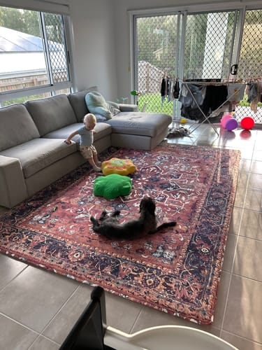 Customer's Artemis Mellow Mat on a tiled living room floor, with a child and a dog enjoying the comfy surface.