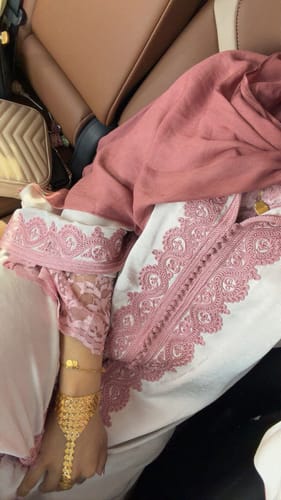 Close-up of a customer wearing the Jellaba Nadae, highlighting the intricate pink embroidery on the chest and cuff.