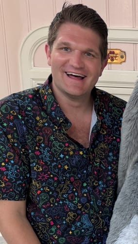 Reviewer smiling while wearing the colorful Disney’s Winnie the Pooh "Beware! Beware! Beware!" shirt.