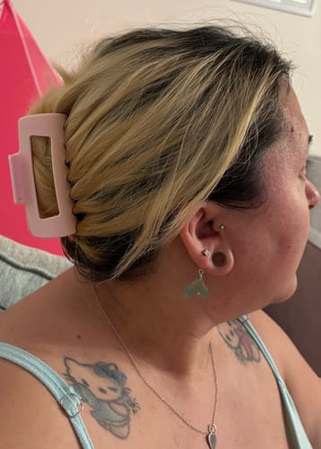 Reviewer showing the light pink cloud clip holding their blonde and brown hair up in a comfortable twist.