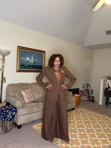 Customer posing with hands on hips, wearing the brown Suiting Pleated Wide-Leg Pant and blazer.