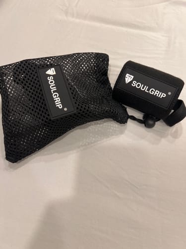Customer's Black-Pro Wrist Wrap shown rolled up next to its black mesh carrying bag.
