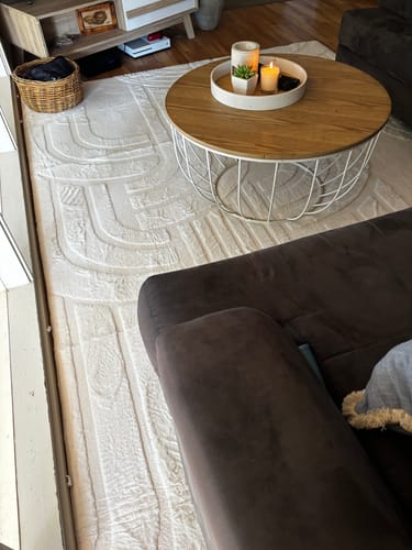 Customer's soft cream Mellow Mat with a carved pattern placed in a living room under a round coffee table.