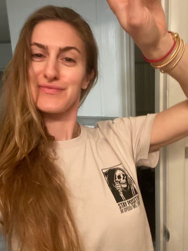 Customer wearing a light-colored MYSTERY TEE with a black skeleton graphic on the chest.