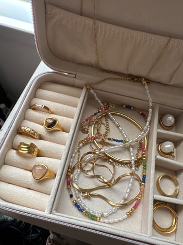 Customer's Kaya Necklace, featuring colorful beads and pearls, stored in a jewelry box with other gold pieces.