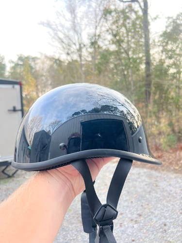 Reviewer holding the glossy black Switchback DOT Reversible Helmet outdoors, showing its low profile.