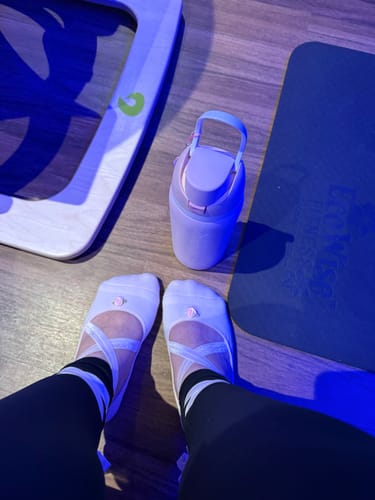 Reviewer's feet wearing the light pink Ballerina Blush grip socks, styled like ballet slippers with straps.