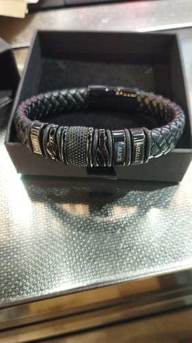 Customer's black braided bracelet with personalized steel beads, shown in its presentation box.