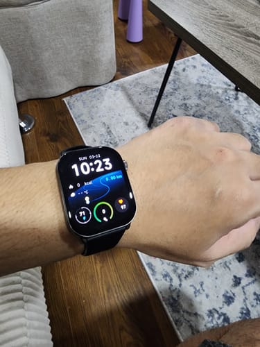 Reviewer's smartwatch with a Black Milanese Loop on their wrist, showing the digital watch face indoors.