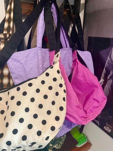 Customer's Wisteria Cloud Bag hanging up as part of a collection with other colorful bags.