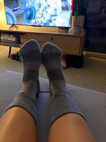 Reviewer relaxing with their feet up, wearing the comfortable grey Ankle Socks.