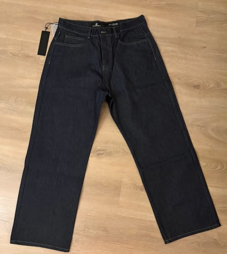 Rezensentenfoto der Star Denim 'Raw Blue' Jeans, flach ausgebreitet auf einem Holzboden.