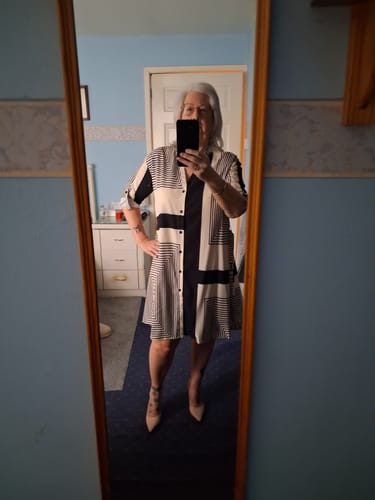 Customer taking a mirror selfie wearing the button printed loose dress without the belt, showing a relaxed fit.