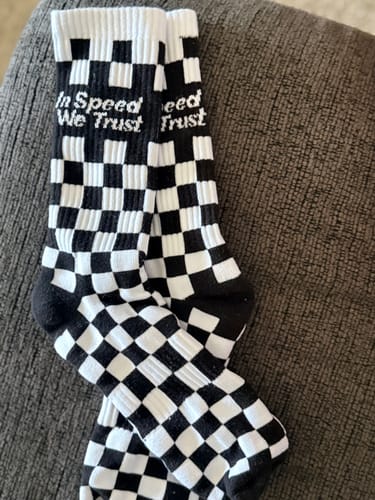 Customer's black and white Checkers Crew Socks laid out, showing the 'In Speed We Trust' text on the cuff.