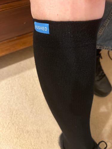 Close-up of a reviewer wearing the black Performance Eucalyptus Compression Sock, showing its comfortable fit below the knee.