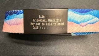 Customer's colorful Hold On, Pain Ends Bracelet shown close-up with a black medical ID tag.