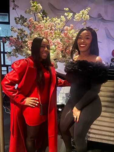 Reviewer poses in the red Naked Mock Neck Mini Dress, worn under a matching red coat indoors.