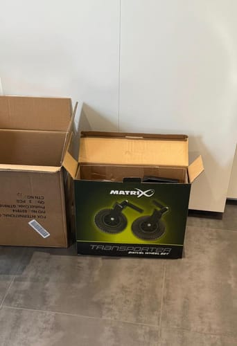 Recensent toont de geopende doos van de TRANSPORTER SWIVEL WHEEL SET.