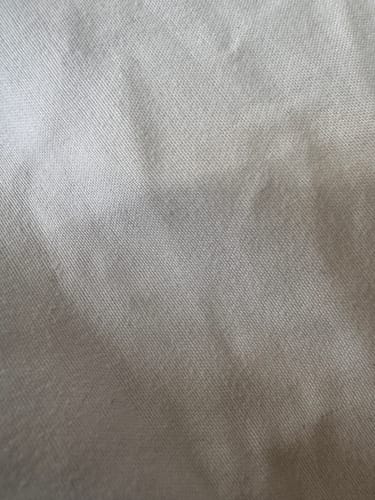 Close-up of a customer's white duvet, clean and free of pet hair after using the Laundry Pet Hair Removal Fish.