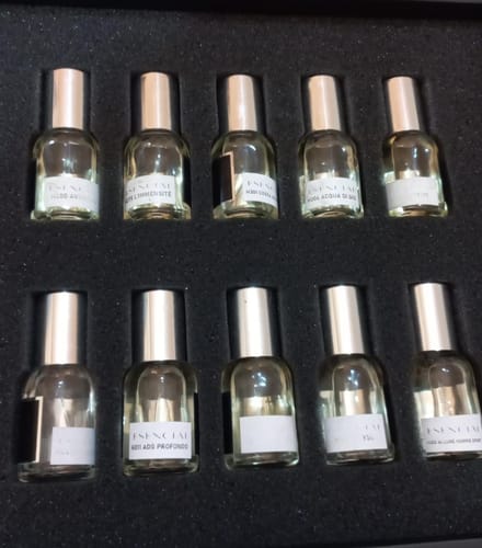 Cliente mostrando el Set de 10 Perfumes perfectamente ordenados dentro de su estuche negro.