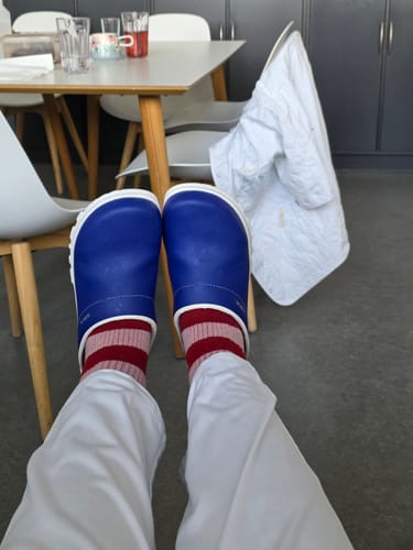 Anmelder slapper af på arbejde iført røde og lyserøde stribede støttestrømper.