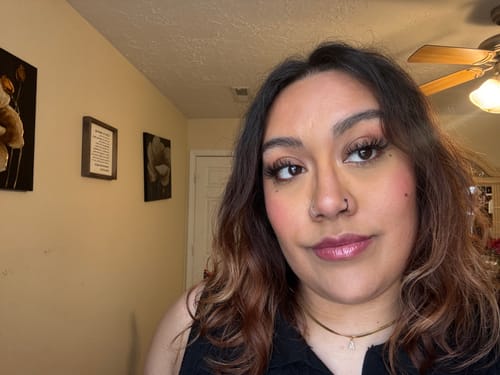 Reviewer wearing the gold Melly Initial Herringbone Necklace with its small initial charm.