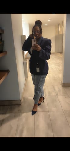 Reviewer takes a mirror selfie wearing the Pinstripe Suited Blazer, showing its power shoulders and fit with jeans.