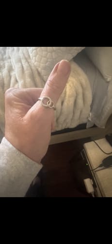 Reviewer's hand wearing the Forever Linked Ring, showing the detailed interlocking circles on their finger.