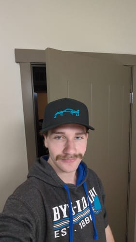 Customer wearing the black 80Eighty® Limited Edition DCG#87 Hat with its bright blue car logo.