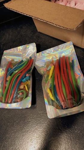 Customer's two holographic bags filled with Strawberry Pencils and other colorful candies.