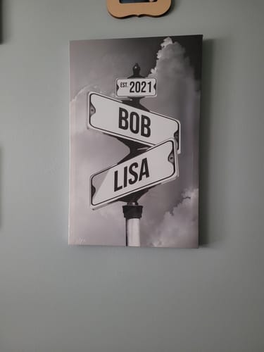 Customer's personalized street sign canvas with the names 'Bob' and 'Lisa' and 'EST. 2021' hanging on a wall.