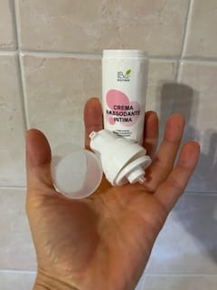 Recensore mostra il flacone smontato della Crema Rassodante Intima nel palmo della mano.