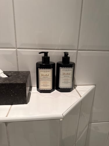 Recensent toont producten uit de Istanbul-lijn, waaronder handlotion, op een witte badkamerplank.