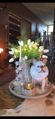 Foto van een klant van het witte tulpenboeket, sfeervol gearrangeerd in een vaas met lichtjes.