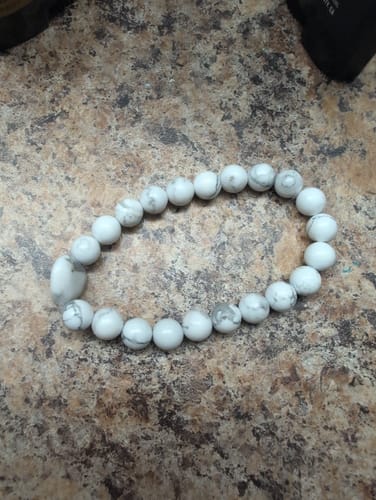 Reviewer's white howlite bead bracelet from the monthly crystal club on a countertop.