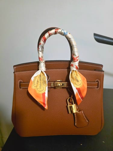 Customer's brown textured LALUVA Warkin Bag, styled with a colorful scarf on the handle and featuring its gold lock hardware.